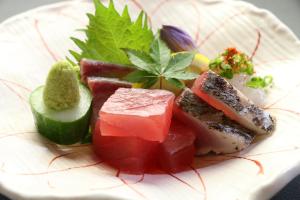 a plate of food with meat and vegetables on it at Minshuku Asogen in Aso