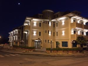 a large yellow building with lights on it at night at Aerhotel Phelipe in SantʼEufemia Lamezia