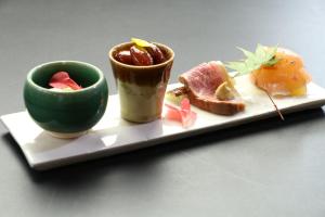 a plate with two cups of food on a table at Minshuku Asogen in Aso