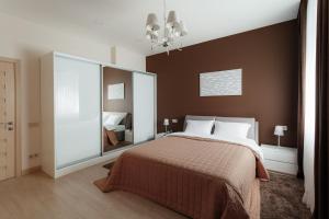 ein Schlafzimmer mit einem großen Bett und einem Spiegel in der Unterkunft Arcadia Villa Apartments in Odessa + 100 Fotos