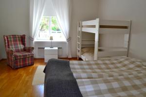 a bedroom with a bunk bed and a chair at Villa Baumgartner in Loviisa