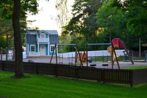 a playground in a park with a house in the background at Villa Baumgartner in Loviisa