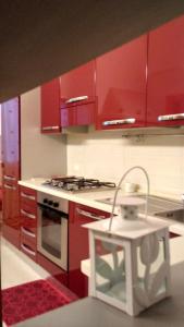 波利尼亞諾阿馬雷的住宿－La Dimora del Gelso Rosso，厨房配有红色橱柜和炉灶烤箱
