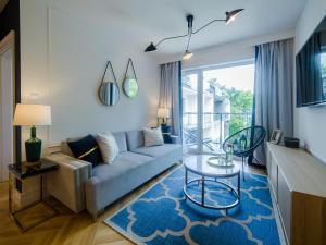 a living room with a couch and a glass table at Apartament Dwie Sosny Sunnyway in Ustronie Morskie