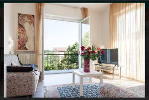 uma sala de estar com um vaso de flores sobre uma mesa em VeronaView Apartment x5 em Verona