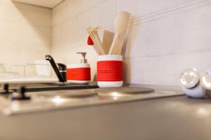 a kitchen counter with two cups and wooden chopsticks at Grey Studio II in Wrocław +22 photos