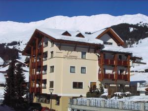 a large building with snow on top of it at Hotel Garni Lawens in Serfaus