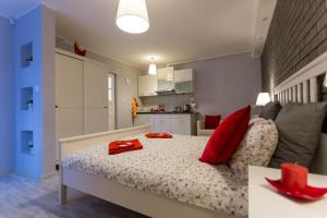 a bedroom with a bed with red pillows on it at Grey Studio II in Wrocław