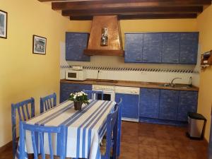 una cocina con armarios azules y una mesa con flores. en Martikotenea I & II, en Errazu