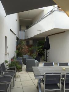 un patio con sillas, una mesa y una sombrilla en appartement Calvi en Calvi