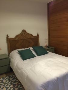 um quarto com uma grande cama branca e uma cabeceira em madeira em appartement Calvi em Calvi