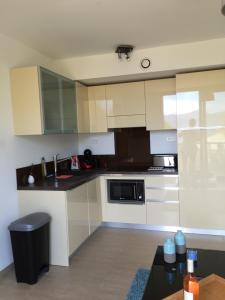 uma cozinha com armários brancos e um balcão preto em appartement Calvi em Calvi