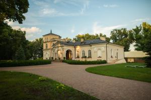 a large white house with a driveway at Dwór Ujazdowski in Nielisz