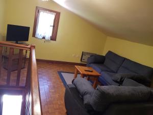 uma sala de estar com um sofá e uma televisão em Martikotenea I & II em Errazu