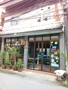 une façade de magasin avec portes en verre et plantes en pot dans l'établissement Baan Jaidee Guesthouse, à Trat