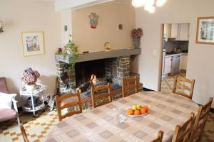 a dining room with a table and a fireplace at La Maison du Soleil in Saint-Gaudéric