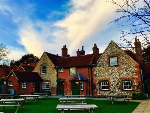 a brick building with picnic tables in front of it at The Stag and Huntsman at Hambleden in Henley on Thames