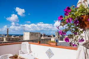 a balcony with a chair and a view of the city at Giulia e Pietro - Marettimo Apartments in Marettimo