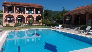 una grande piscina di fronte a una casa di Gregory-Vassilis Apartments a Dassia
