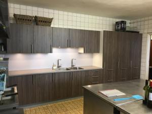 a kitchen with wooden cabinets and a sink at De Distelhoeve in Helvoirt