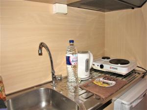 una bottiglia d'acqua seduta accanto a un lavandino in cucina di Gorgona Hotel a Patitiri