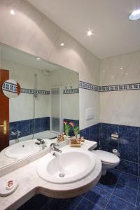 a bathroom with a sink and a tub and a mirror at Hotel Centro Benessere Gardel in Arta Terme