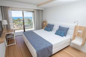 a bedroom with a bed and a large window at Alfagar Aparthotel in Albufeira