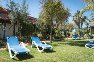 three chairs sitting in the grass next to a house at Hacienda Sajorami in Zahora