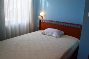 um quarto com uma cama com uma almofada branca em Captain's House em Meganisi