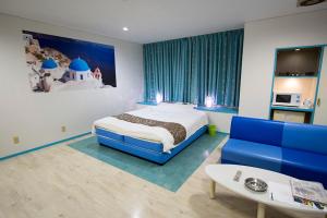 Un dormitorio con una cama y un sofá azul. en Hotel JIN (Adult Only), en Hamamatsu