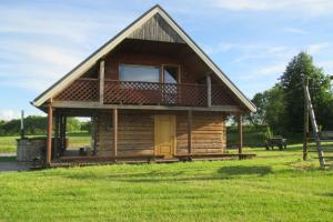 a log cabin with a porch and a balcony at Krustceles in Baltinava