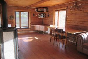 a dining room with a wooden table in a cabin at Krustceles in Baltinava
