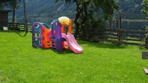 Kinder spielen auf dem Rasen im Hof in der Unterkunft Zachhof in Ellbögen