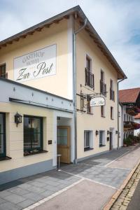 ein Gebäude mit einem Schild, das den verfassungsmäßigen Gasthof liest in der Unterkunft Gasthof - Hotel Zur Post in Neukirchen am Teisenberg