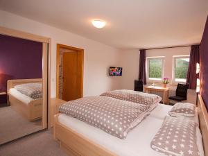 a bedroom with two beds and a chair in it at Pension Droste- Vogt in Schmallenberg