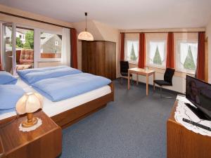 a bedroom with a bed and a desk with a computer at Pension Droste- Vogt in Schmallenberg