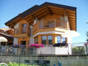 a house with a balcony with flowers on it at B&B La Bottega in Pergine Valsugana