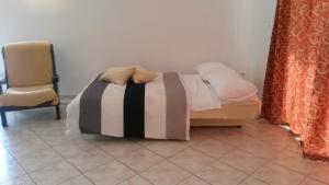 a bedroom with a bed and a chair in a room at Apartman Lana in Banjole