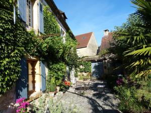 an alley between two buildings with flowers and plants at Maison Chaumont in Vézac