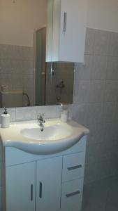 a bathroom with a white sink and a mirror at Apartman Lana in Banjole