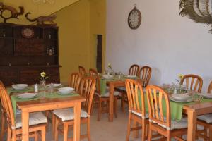 een eetkamer met houten tafels en stoelen en een klok bij Finca Sa Duaia de Dalt in Artá