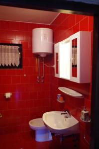 a red bathroom with a white sink and a toilet at Apartment Lukovo - Puskaric in Lukovo