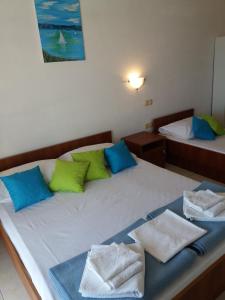1 dormitorio con 2 camas con almohadas verdes y azules en Apartments Boris, en Omiš