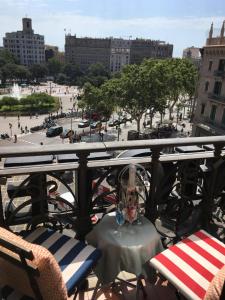 a person sitting on a bench under an umbrella at Hotel Ginebra in Barcelona