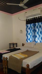 - une chambre avec un grand lit et une fenêtre dans l'établissement Marari Babu Homestay, à Mararikulam