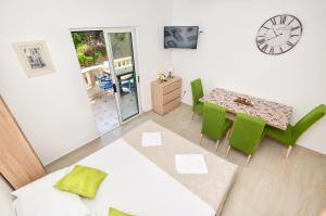 a living room with a table and chairs and a clock at Apartments Mustapic in Makarska