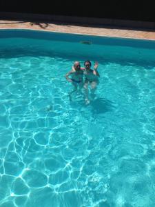 two people are swimming in a swimming pool at Villetta Dolce in Campofelice di Roccella