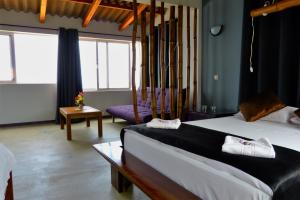 una camera d'albergo con due letti e un divano di kasa Tambla a Ponta do Sol