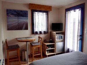 a bedroom with a bed and a table and a microwave at Suite à 800m de la plage in Saint-Lunaire