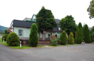 una casa con una valla y árboles delante de ella en Pension U Kaštanů, en Karlovy Vary